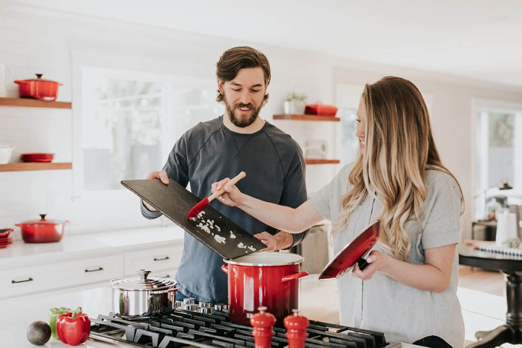A happy couple cooking in the kitchen after securing the right loan with Mike Mackenzie