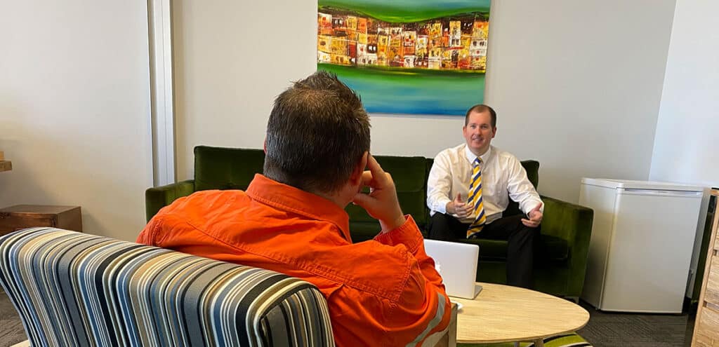 Mike Mackenzie talking diligently to a client about his loan options