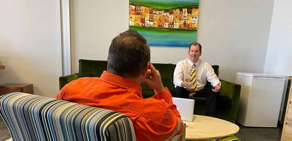 Mike Mackenzie talking diligently to a client about his loan options